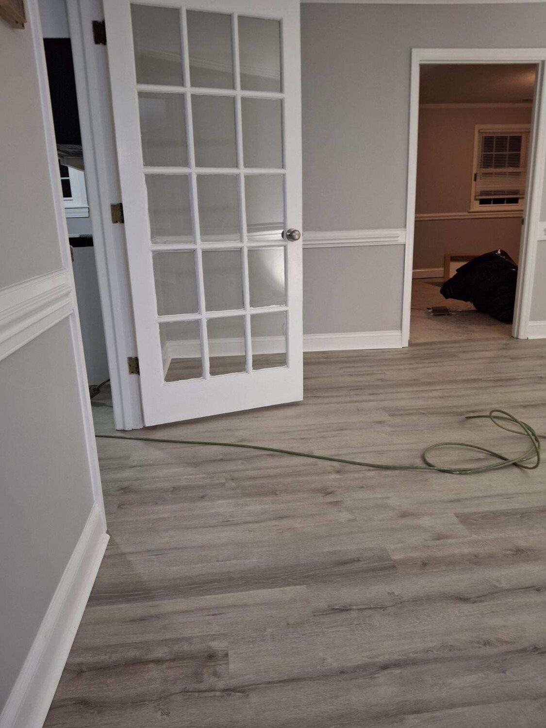 Completed FIG LVP wood-look flooring — French-doors room